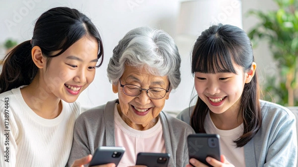 Fototapeta スマホを見ながら孫娘達と談笑するおばあちゃん