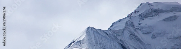 Fototapeta A close-up of a mountain peak in bad weather, leading to the death of climbers in windy weather, snow-capped peaks in the clouds