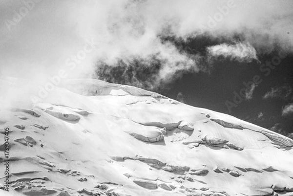 Fototapeta A close-up of a mountain peak in bad weather, leading to the death of climbers in windy weather, snow-capped peaks in the clouds