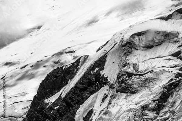 Fototapeta A close-up of a mountain peak in bad weather, leading to the death of climbers in windy weather, snow-capped peaks in the clouds