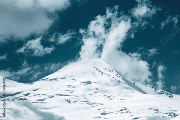 Fototapeta A close-up of a mountain peak in bad weather, leading to the death of climbers in windy weather, snow-capped peaks in the clouds