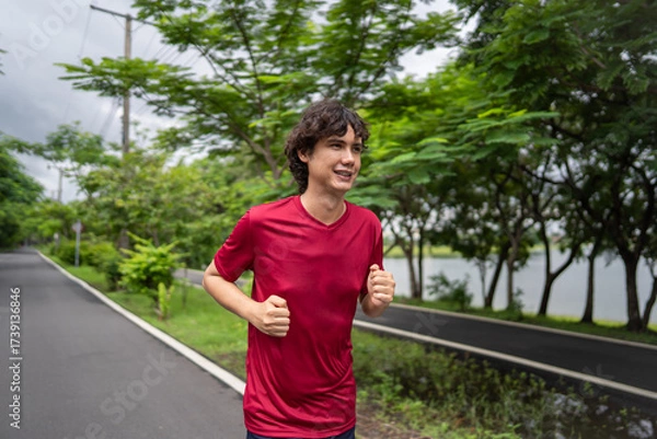 Fototapeta Asian attravtice sportsman doing running exercise alone in the garden.