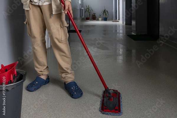 Fototapeta Cleaning a hallway with a mop and bucket in a cozy indoor space during daytime
