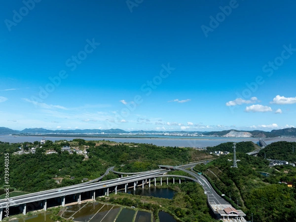 Fototapeta Aerial view of a multi  layered highway interchange with vehicles and greenery