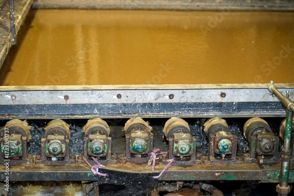 Fototapeta Heavy machinery is engaged in filtering a thick brown liquid in a manufacturing setting. The equipment efficiently separates impurities, ensuring cleaner liquid output