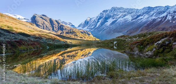 Fototapeta Mountain lake with reflection in swiss alps. Lake Guggisee perfectly reflects scenery in loetschental, valais switzerland