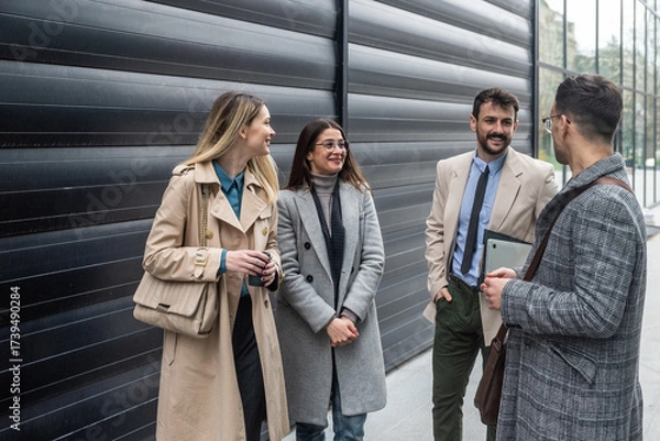 Fototapeta IT experts freelance workers innovative technology developers, working on a new project staff meeting with casual talk in formalwear outside office building before the work. Discussing business people