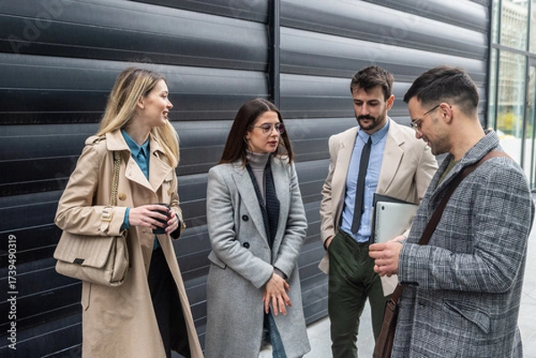 Fototapeta IT experts freelance workers innovative technology developers, working on a new project staff meeting with casual talk in formalwear outside office building before the work. Discussing business people