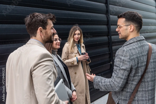 Fototapeta IT experts freelance workers innovative technology developers, working on a new project staff meeting with casual talk in formalwear outside office building before the work. Discussing business people