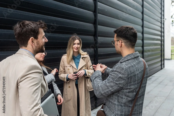 Fototapeta IT experts freelance workers innovative technology developers, working on a new project staff meeting with casual talk in formalwear outside office building before the work. Discussing business people