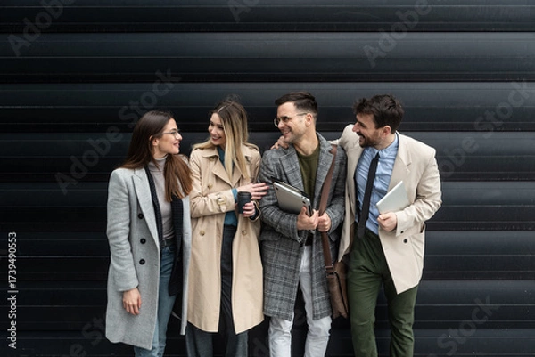 Fototapeta IT experts freelance workers innovative technology developers, working on a new project staff meeting with casual talk in formalwear outside office building before the work. Discussing business people