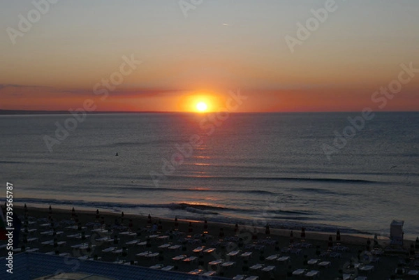 Fototapeta Beautiful early sunrise from the horizon on the sea , illuminated by the sun, which creates reflections orange and yellow shades on the surface of the water.