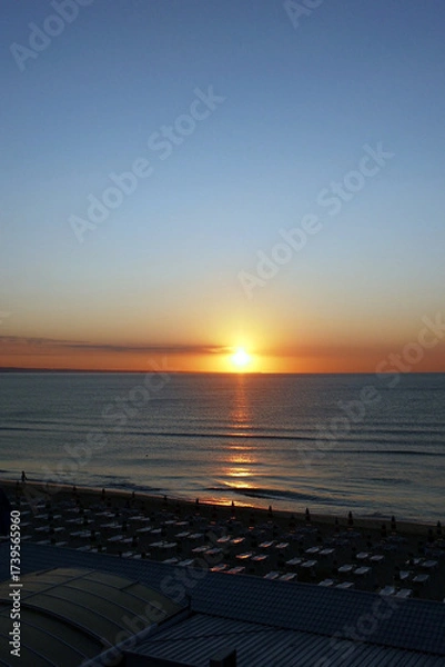 Fototapeta Beautiful early sunrise from the horizon on the sea , illuminated by the sun, which creates reflections orange and yellow shades on the surface of the water.