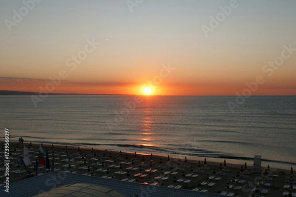 Fototapeta Beautiful early sunrise from the horizon on the sea , illuminated by the sun, which creates reflections orange and yellow shades on the surface of the water.