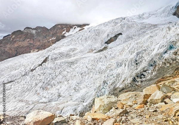 Fototapeta Monte Rosa (Italy) - A mountains view in Valsesia with Monte Rosa mount peak of Alps, alpinistic paths to Rifugio Modena and Capanna Margherita refuge, with snow glacier and alpinists.