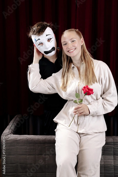 Fototapeta A mime in love and a girl with a rose on a theater stage. Close-up.