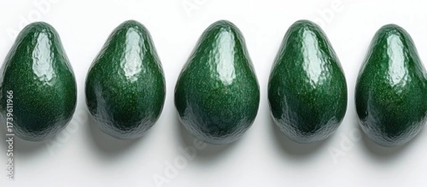 Fototapeta Avocados arranged in a row on white background. Food photography