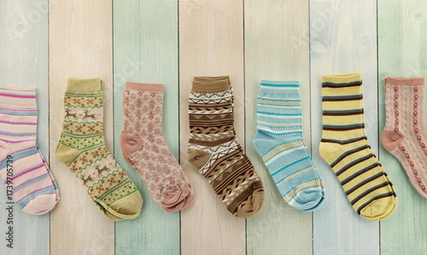 Fototapeta Colorful socks on a multicolored striped background. A panorama of socks for the cold seasons.