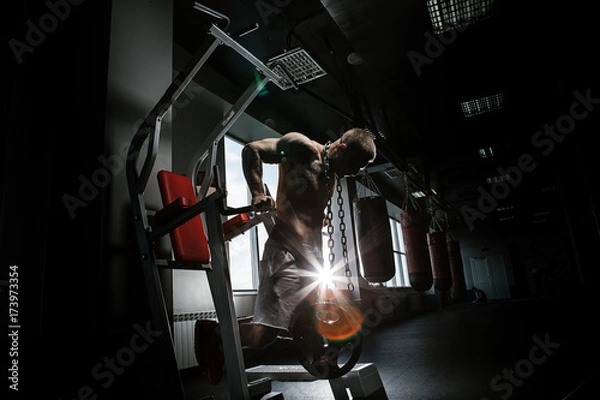 Obraz Strong man with tatoo working in gym 