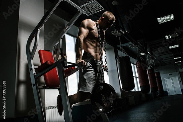 Obraz Strong man with tatoo working in gym 