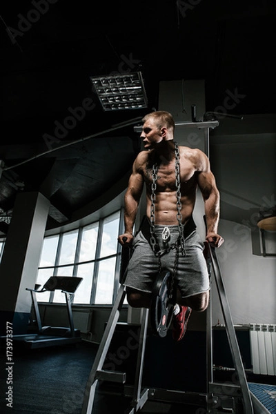 Obraz Strong man with tatoo working in gym 