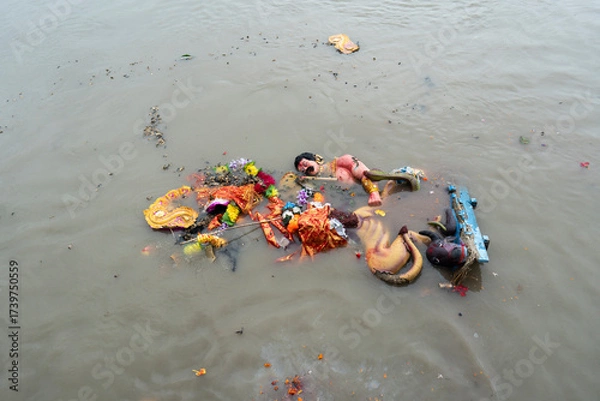 Fototapeta Hindu devotees immerse a clay idol of Goddess Durga into the Brahmaputra River on the concluding day of the Durga Puja festival