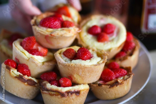 Fototapeta Fresh strawberry-topped cupcakes on rustic table.