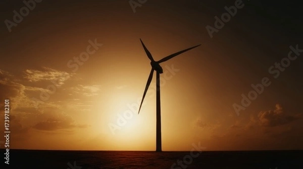 Fototapeta Silhouette of a wind turbine against a sunset backdrop with expansive open fields stretching to the horizon where the su