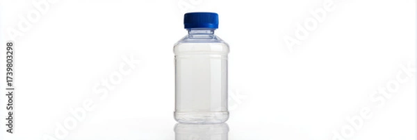 Fototapeta A clear plastic water bottle with a blue screw cap is positioned upright on a white surface. The background is bright and minimal, showcasing the bottle's design and color, banner