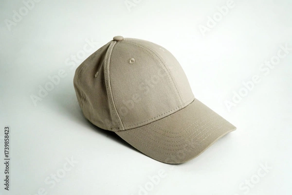 Fototapeta A blank gray baseball cap sits on a clean white background, viewed from a straight-on perspective. This versatile image is perfect for mockups, clothing, or accessory concepts.

