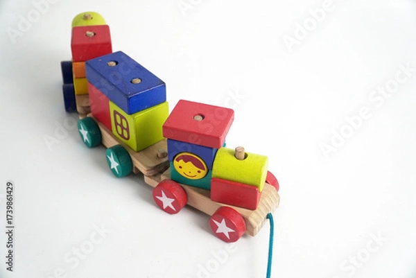 Fototapeta A colorful wooden toy train with blocks of different shapes and numbers, isolated against a white background. This image is perfect for concepts of childhood, learning, games, and vintage toys.

