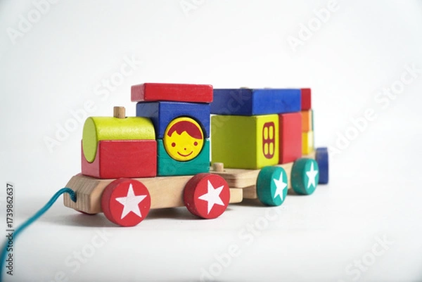 Fototapeta A colorful wooden toy train with blocks of different shapes and numbers, isolated against a white background. This image is perfect for concepts of childhood, learning, games, and vintage toys.

