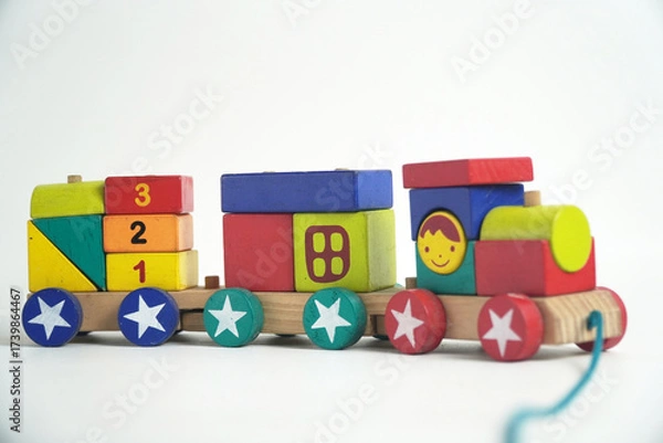 Fototapeta A colorful wooden toy train with blocks of different shapes and numbers, isolated against a white background. This image is perfect for concepts of childhood, learning, games, and vintage toys.

