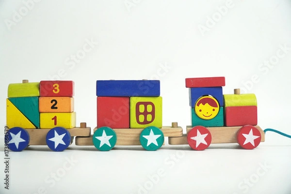 Fototapeta A colorful wooden toy train with blocks of different shapes and numbers, isolated against a white background. This image is perfect for concepts of childhood, learning, games, and vintage toys.

