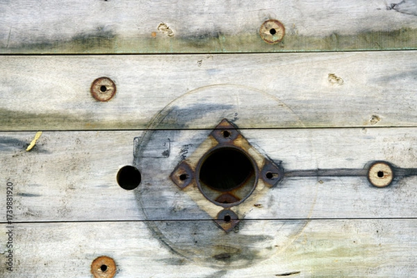 Fototapeta Textured Wooden Surface with Holes and Rusty Fixtures Close-Up