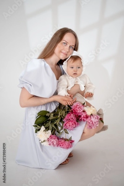 Obraz mom with a baby little daughter with peony flowers on a white isolated background, space and room for text