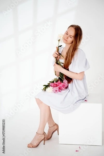Obraz a young beautiful girl with peony flowers on a white isolated background, space and room for text