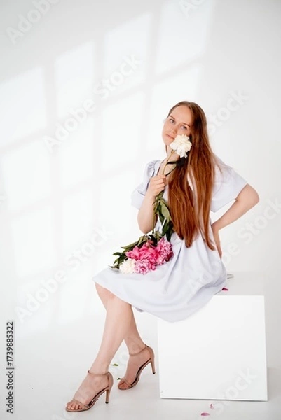 Obraz a young beautiful girl with peony flowers on a white isolated background, space and room for text