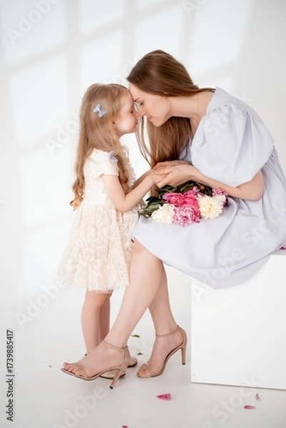Obraz mom with a baby little daughter with peony flowers on a white isolated background, space and room for text