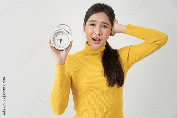 Fototapeta Stress Asia young woman show clock alarm, lady is late appointment or work or class study, overslept, difficulty get up in mornings, time worried, not on time, sleepy, over due, Hurry up time