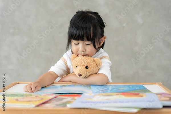 Fototapeta Happy Asian children relax read book at home. daughter and reading a story. learn development, childcare, laughing, education, storytelling, practice, imagine, reduce addiction mobile phone