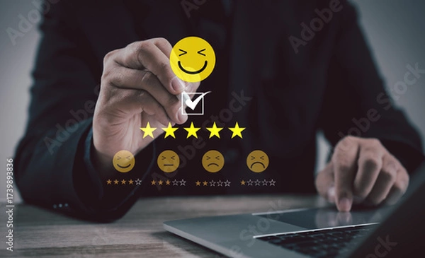 Fototapeta Professional selecting five-star rating with smiling emoji on digital interface, representing customer satisfaction, feedback, service review, quality assurance, and business reputation.