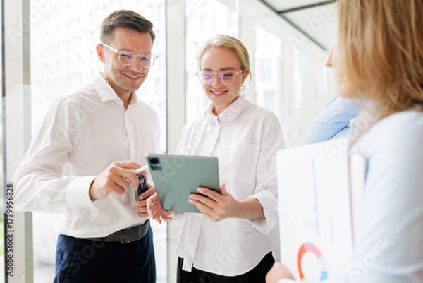 Fototapeta Business professionals collaborating in a modern office setting with technology
