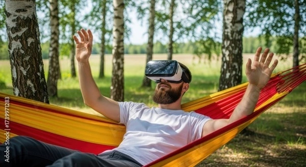 Obraz Young caucasian male relaxing in hammock with virtual reality headset in forest