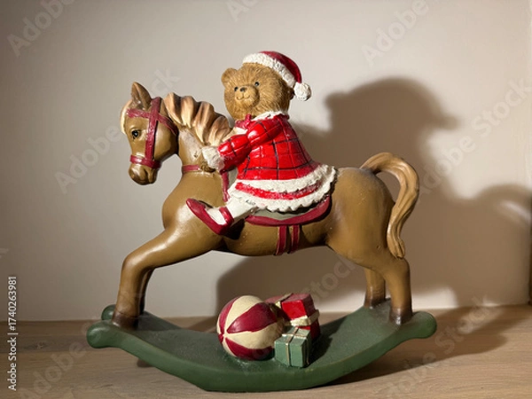 Fototapeta Christmas toy bear on rocking horse with gifts, festive holiday decoration