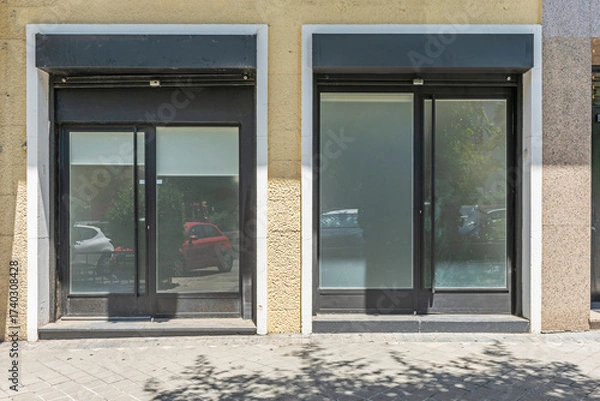 Fototapeta Renovated facade of a small establishment with a black aluminum frame and clear glass for maximum visibility.