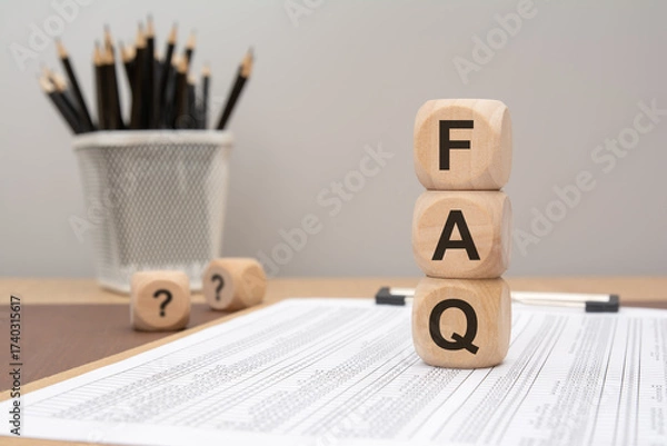 Fototapeta wooden cubes spelling FAQ placed on printed document