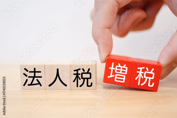 Fototapeta 法人税増税を示す木製ブロック。白背景。コピースペースあり。