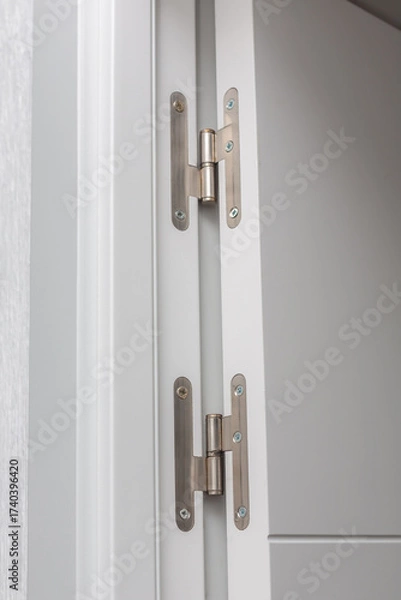 Fototapeta Close-up view of modern cabinet hinges showcasing sleek design and metallic finish, emphasizing functionality and craftsmanship in contemporary interior spaces