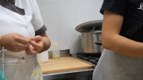 Fototapeta Passionate chefs meticulously crafting pumpkin stuffed fall season tortellini in a cozy professional kitchen creating delicious Italian food with intense focus evident in close-up shots